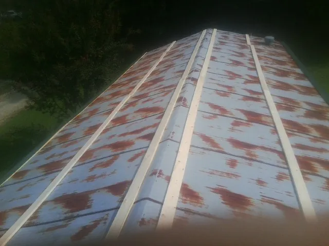 Rusted metal roof panels with new wood purlins before replacement — Storm Damage Roof Repair in Talisheek by Roofing Brothers