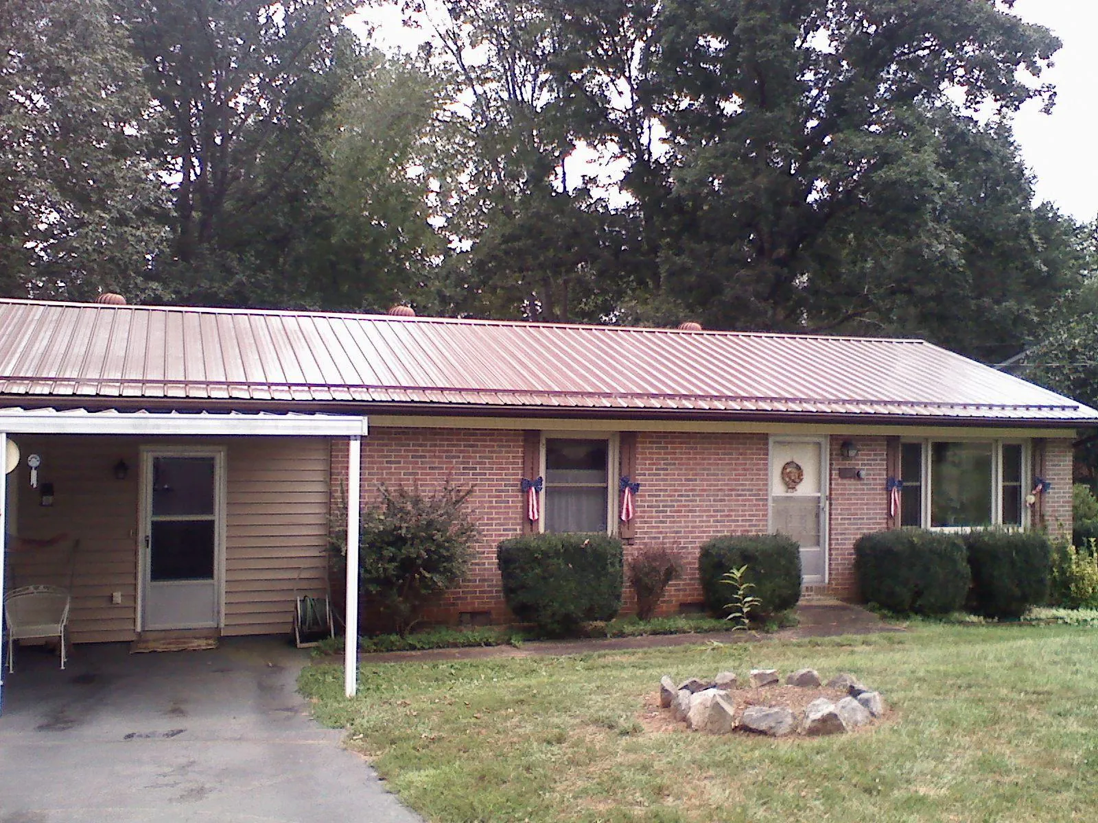 Bronze metal roof and carport on a brick ranch home — Roof Repair work by our crew in Talisheek